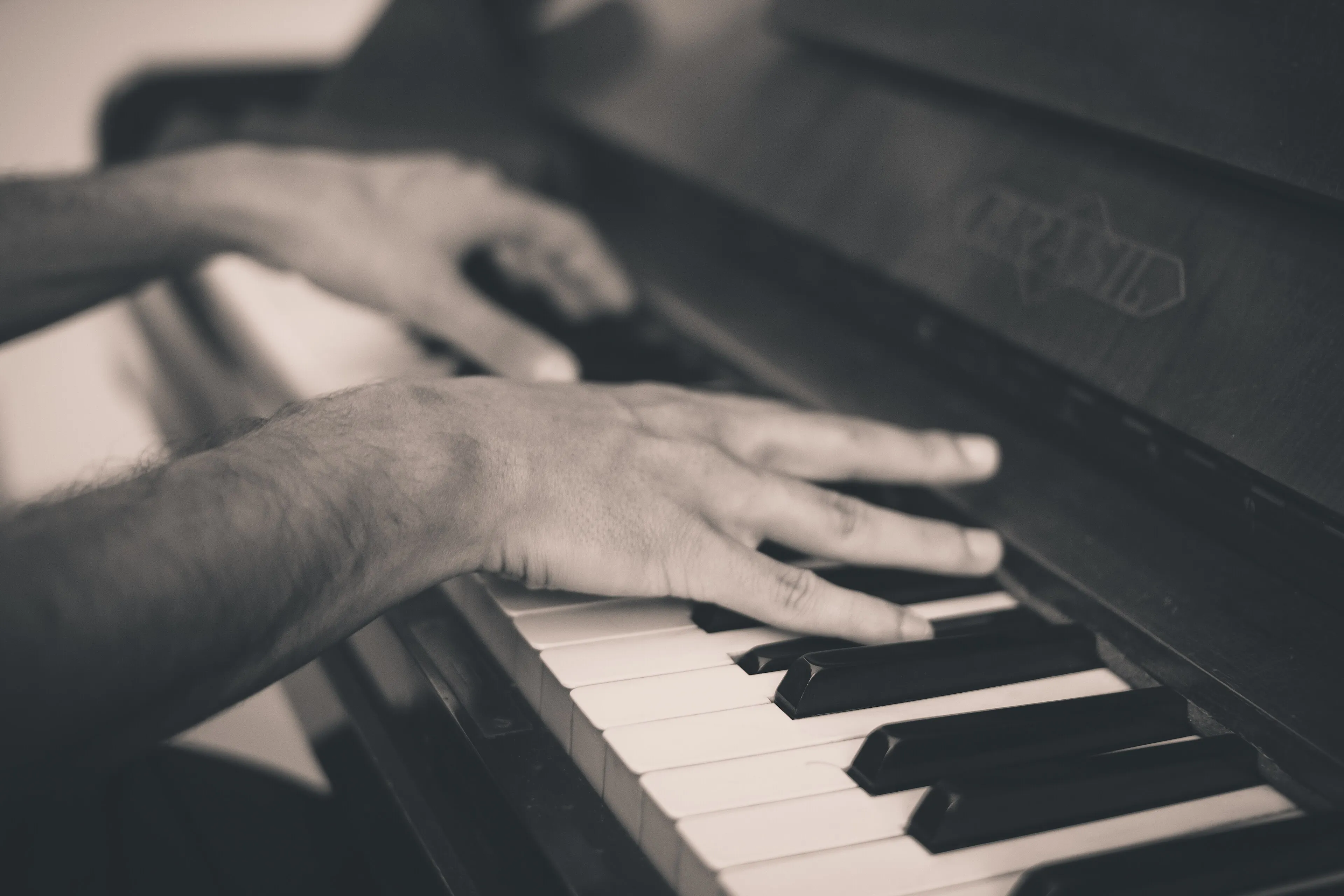 Manos de pianista sobre el teclado en blanco y negro (foto de muestra)